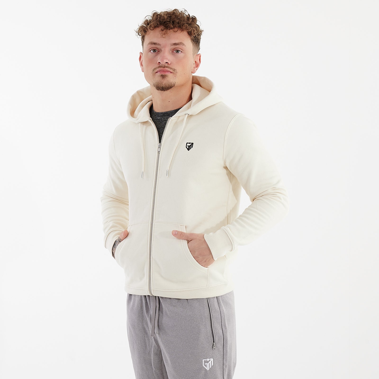 Side view of a man wearing a white cultivator zip through hoodie