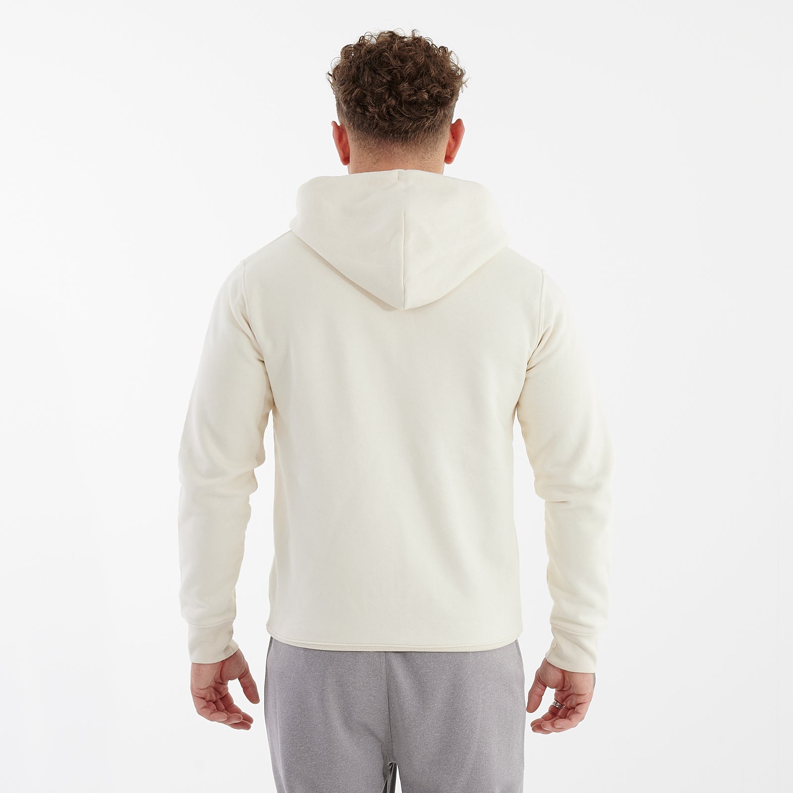 Back view of a man wearing a white cultivator zip through hoodie