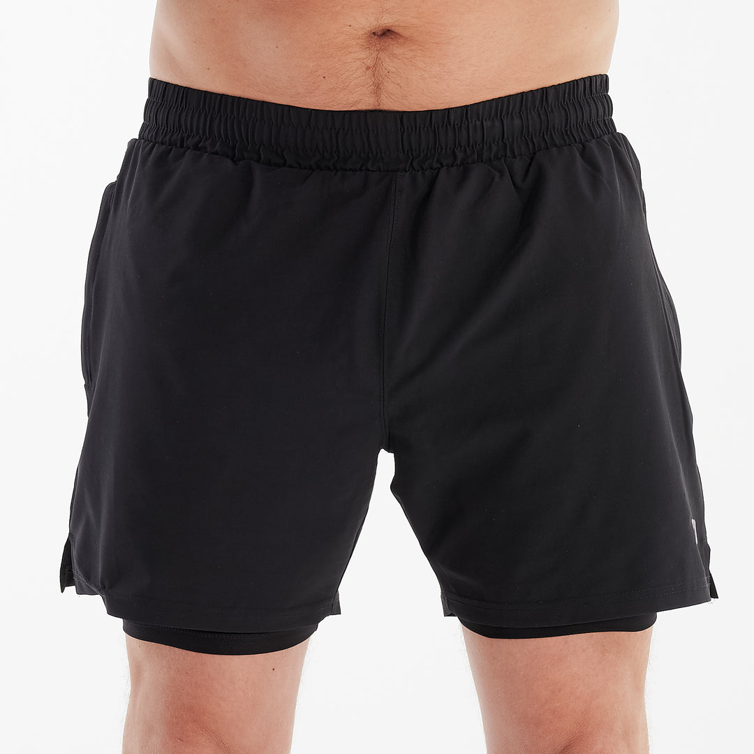 Front view of a man wearing dual layer performance shorts.