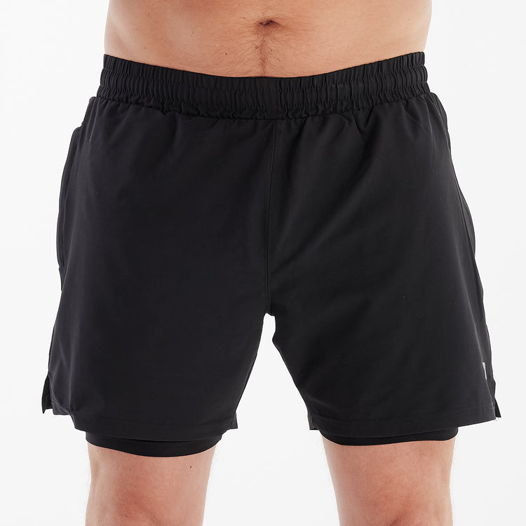 Front view of a man wearing dual layer performance shorts.