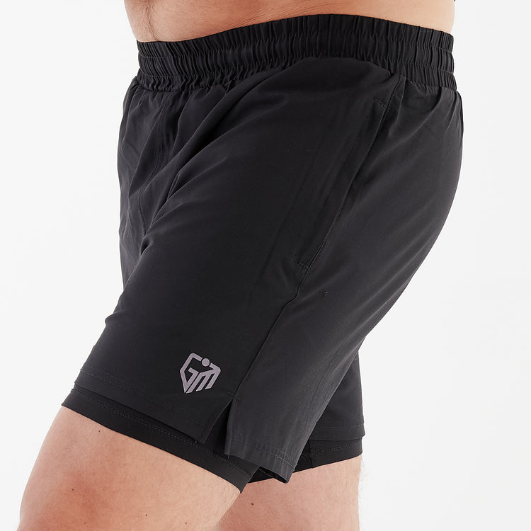 Side view of a man wearing dual layer performance shorts