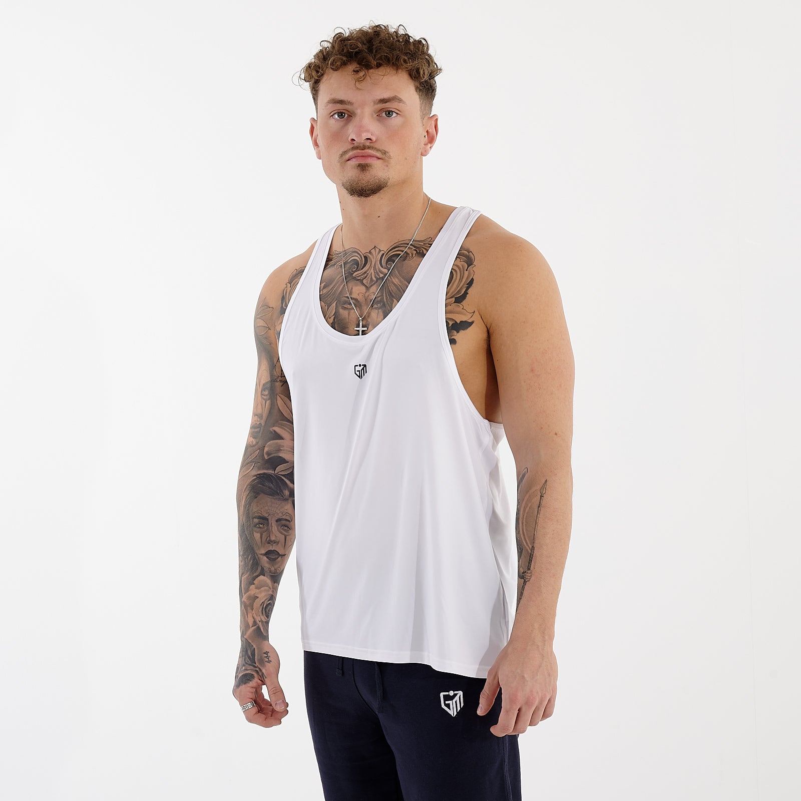 Side view of a man wearing a white essential tank top