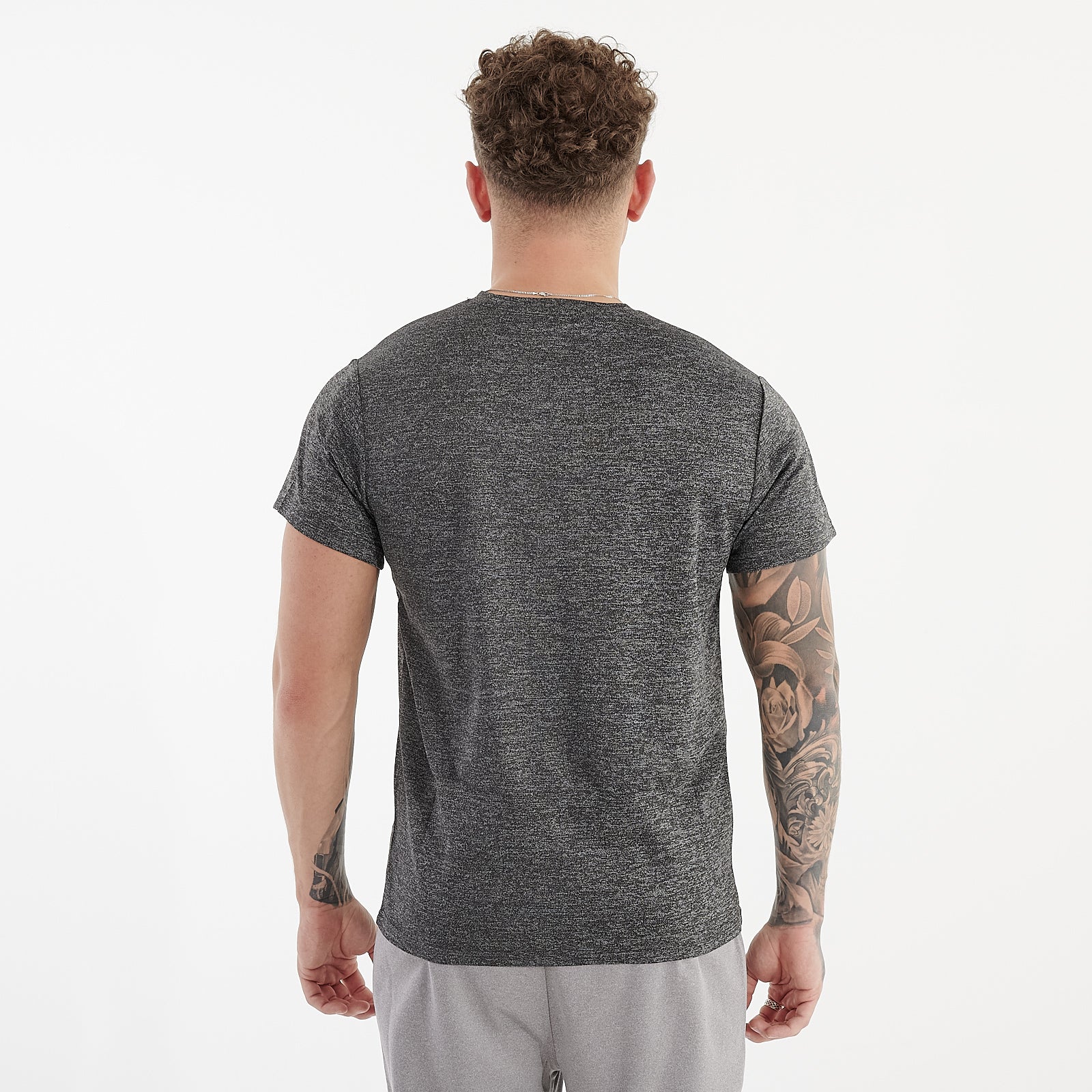 Back view of a man wearing a asphalt performance recycled tee