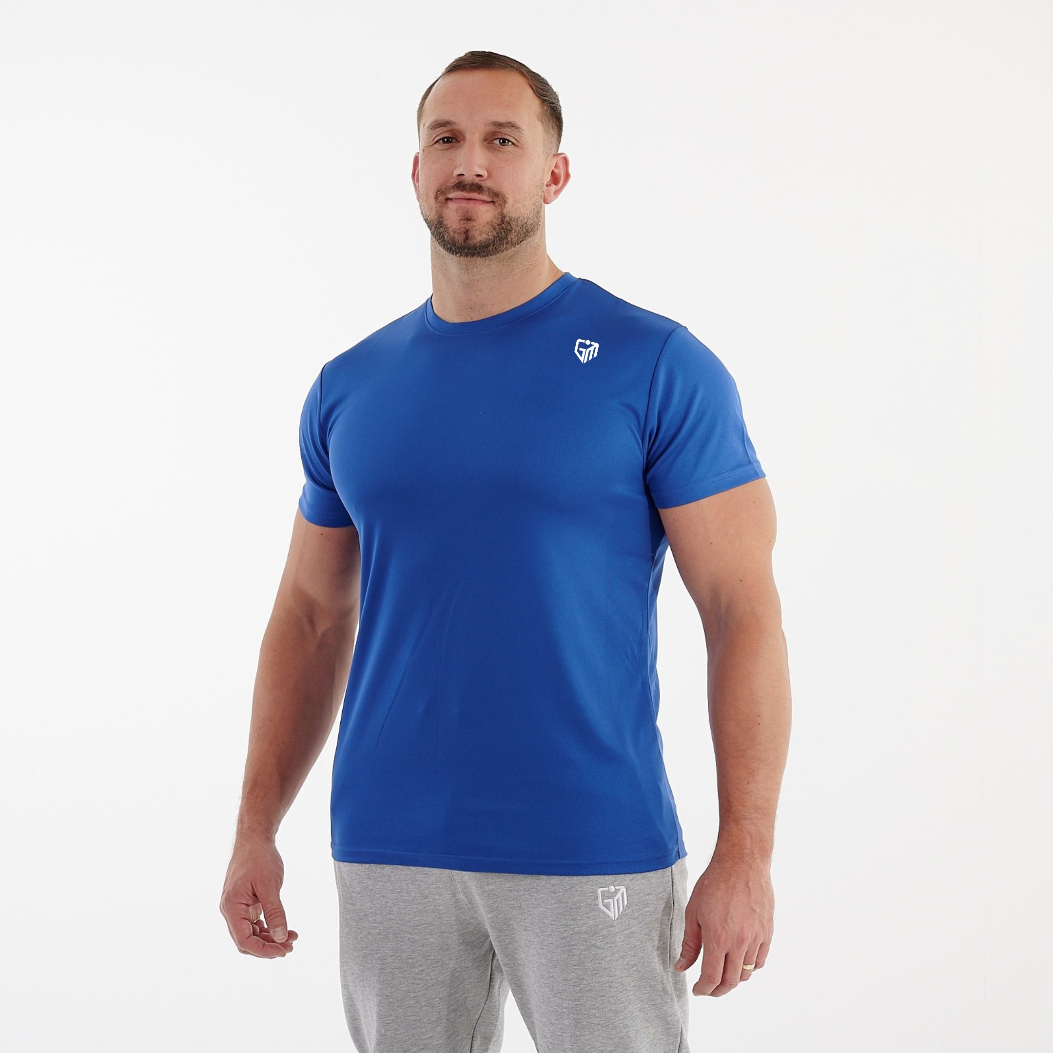 Side view of a man wearing a blue performance recycled tee.