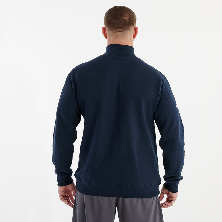 Back view of a man wearing a 1/4 zip navy sweatshirt