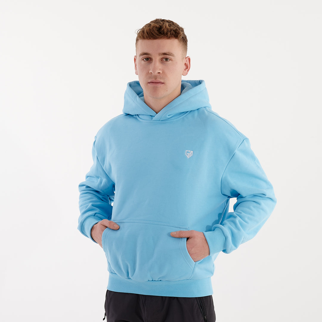 Side view of a man wearing a baltic blue oversized heavy hoodie