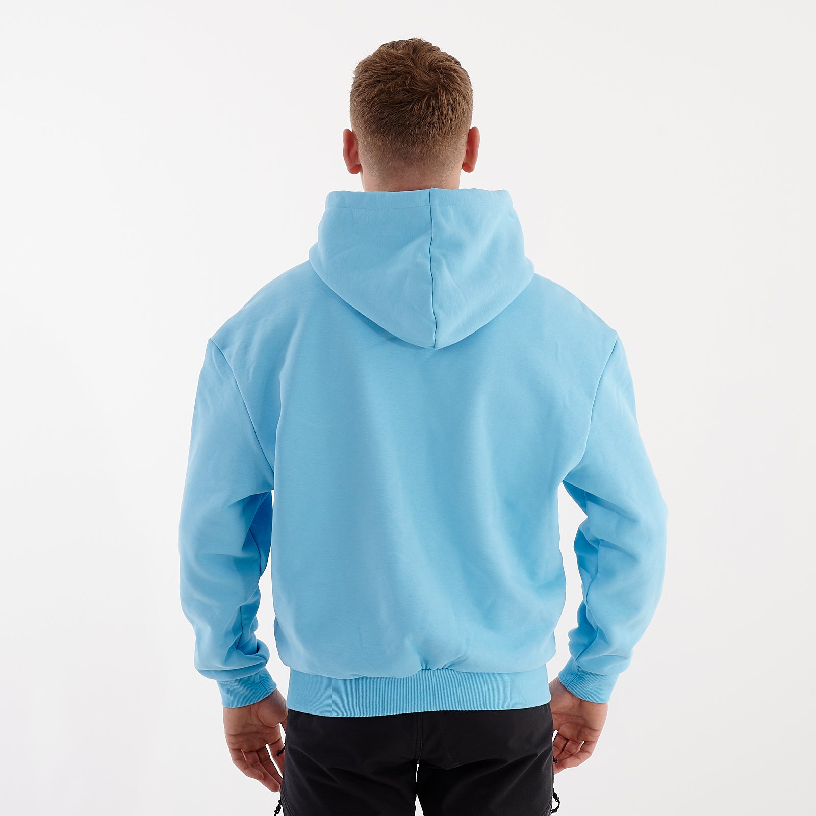 Back view of a man wearing a baltic blue oversized heavy hoodie