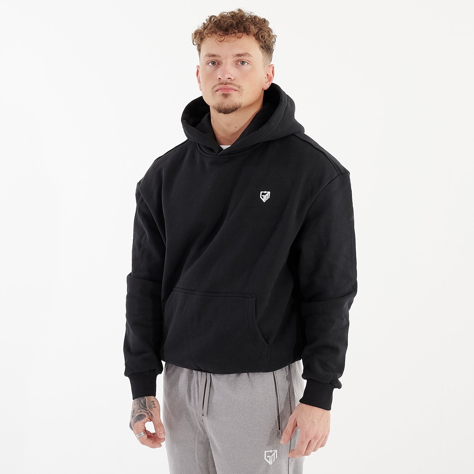 Side view of a man wearing a black oversized heavy hoodie