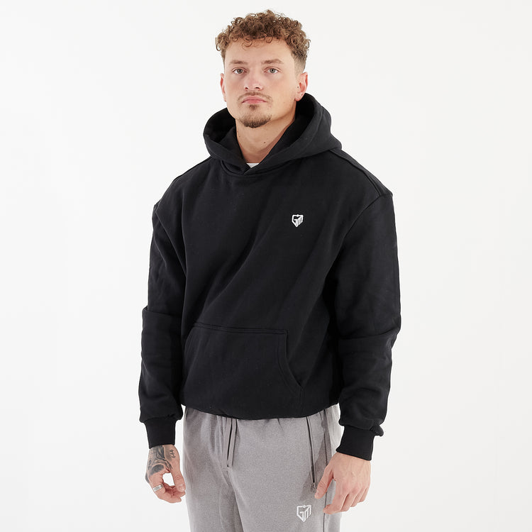 Side view of a man wearing a black oversized heavy hoodie