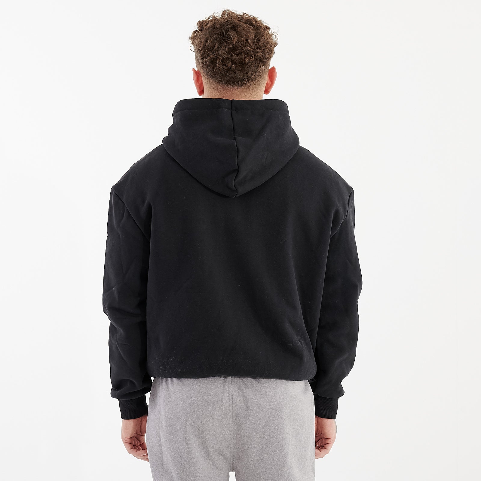 Back view of a man wearing a black oversized heavy hoodie