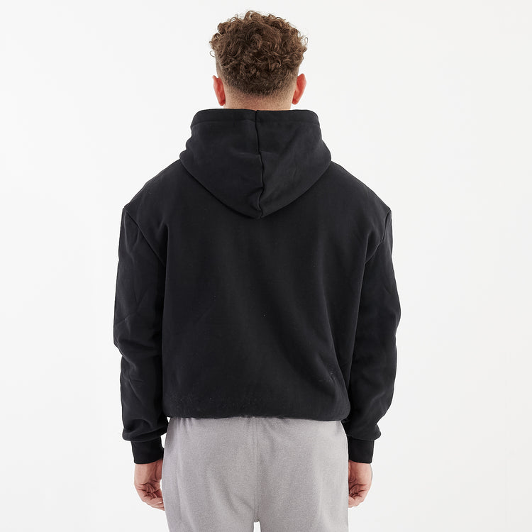 Back view of a man wearing a black oversized heavy hoodie