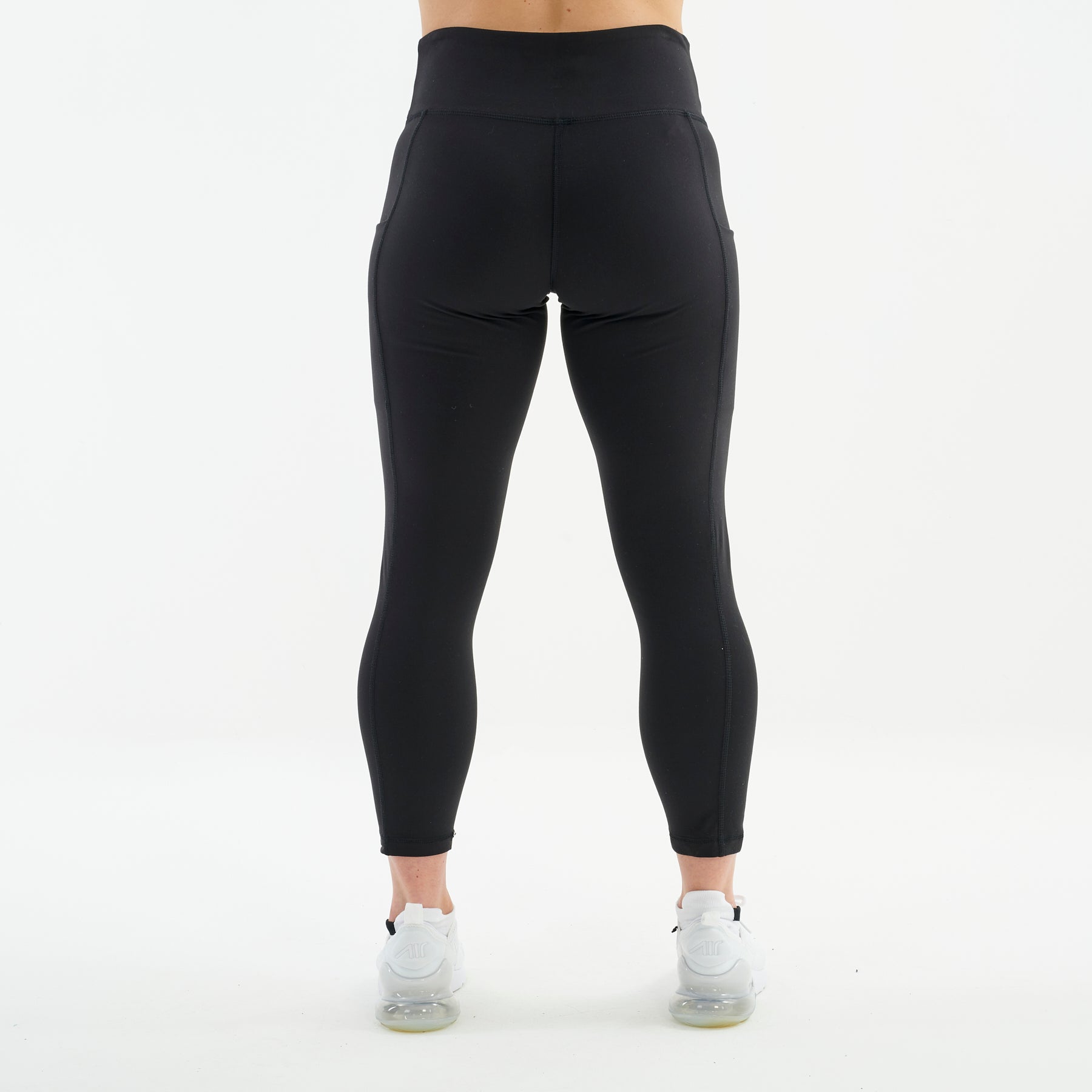 Back view of a woman wearing black 7/8 recycled performance leggings
