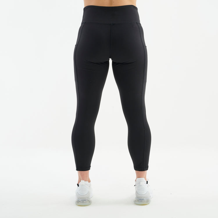 Back view of a woman wearing black 7/8 recycled performance leggings