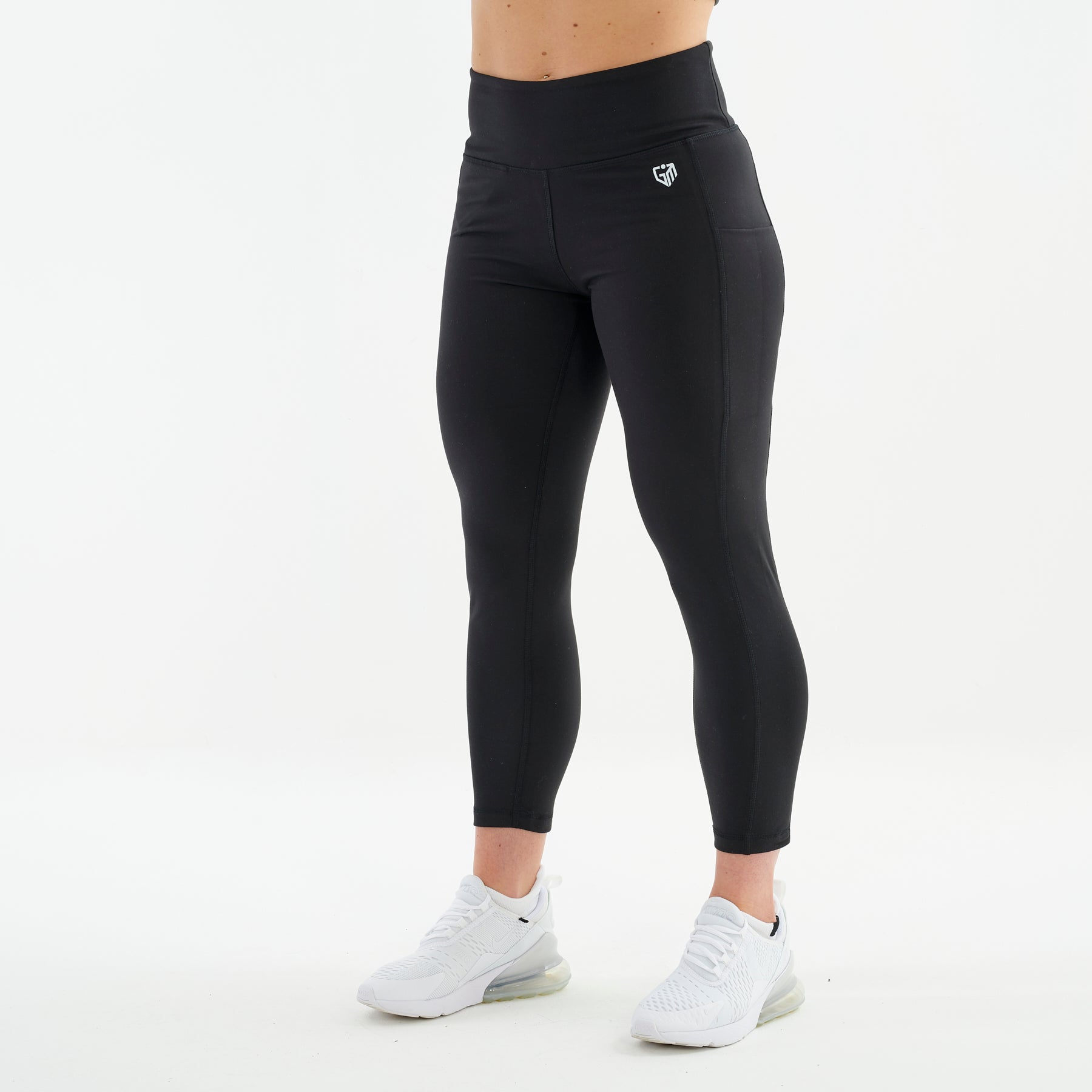 Side view of a woman wearing black 7/8 recycled performance leggings