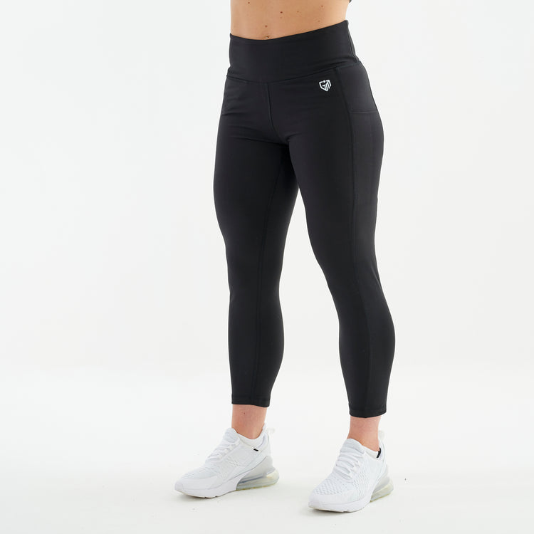 Side view of a woman wearing black 7/8 recycled performance leggings