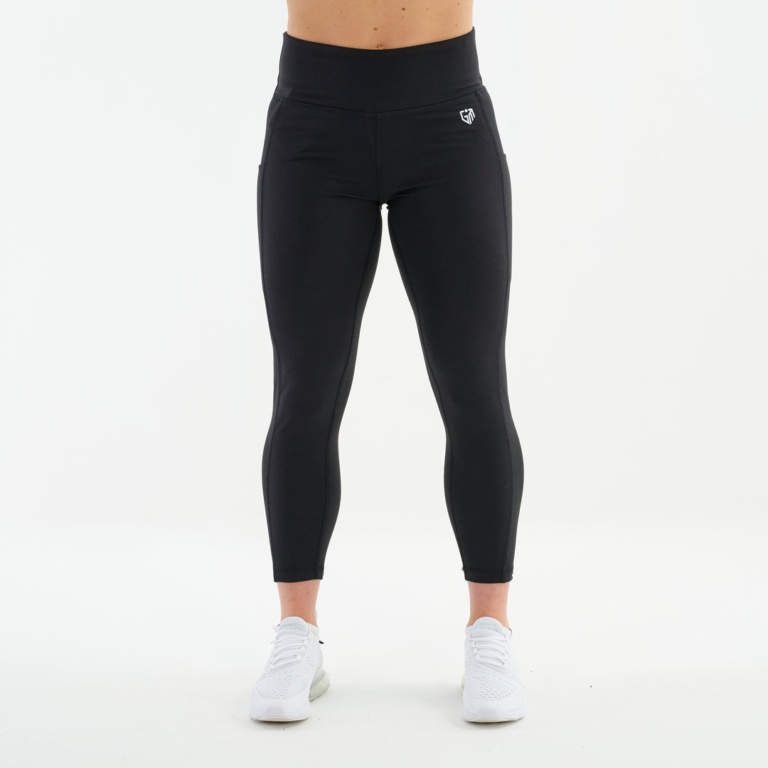 Front view of a woman wearing black 7/8 recycled performance leggings