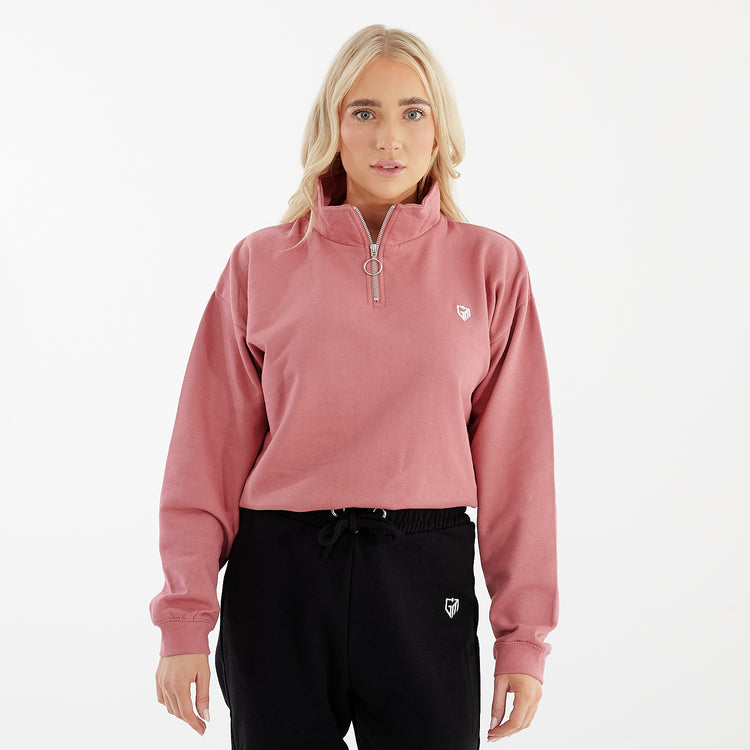 Front view of a women wearing a pink cropped 1/4 zip sweatshirt