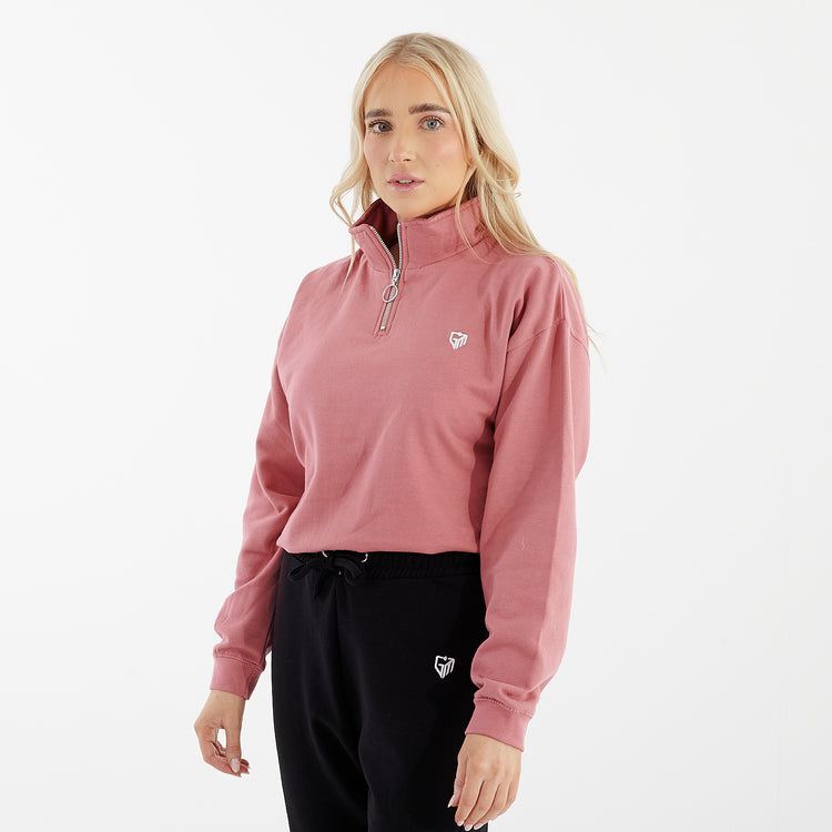 Side view of a women wearing a pink cropped 1/4 zip sweatshirt
