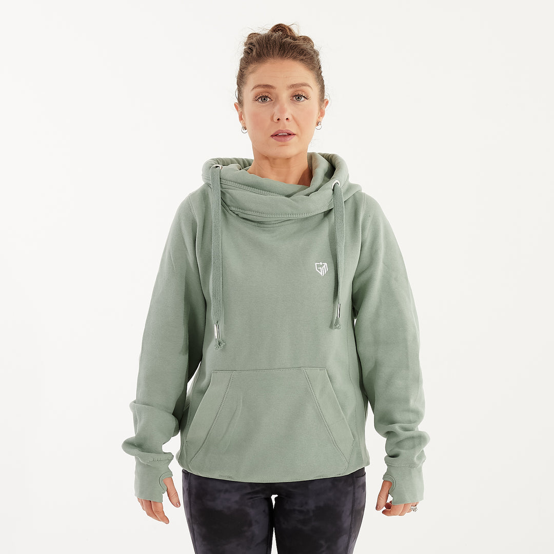 Front view of a woman wearing a dusty green heavyweight hoodie