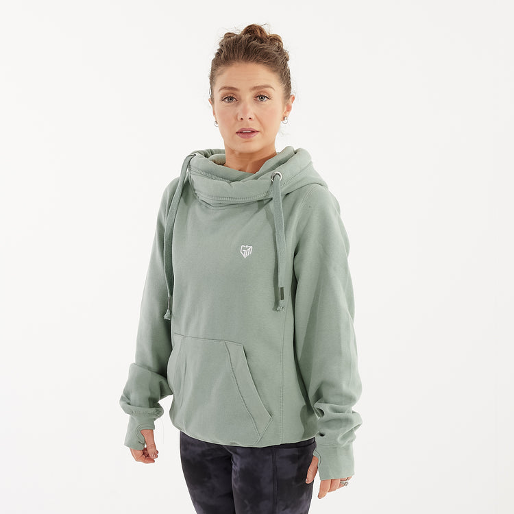 Side view of a woman wearing a dusty green heavyweight hoodie