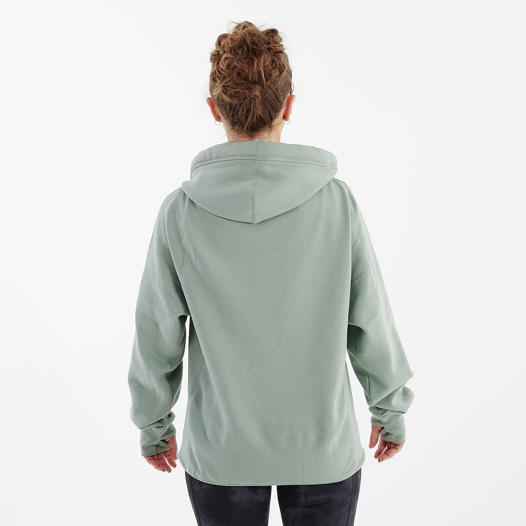Back view of a woman wearing a dusty green heavyweight hoodie