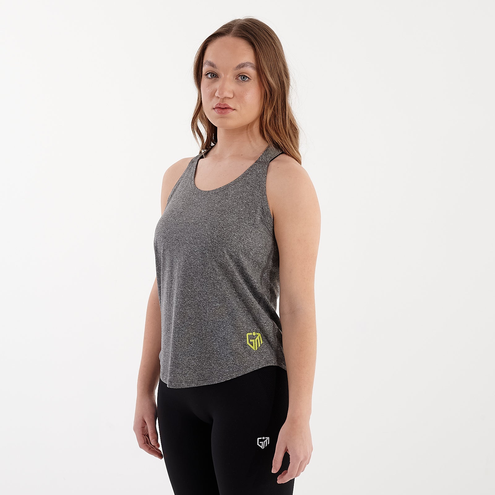 Side view of a woman wearing a grey melange strappy back performance vest.