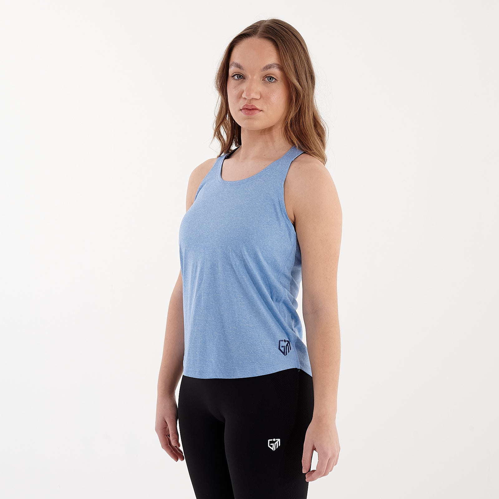 Side view of a woman wearing a sky blue strappy back performance vest