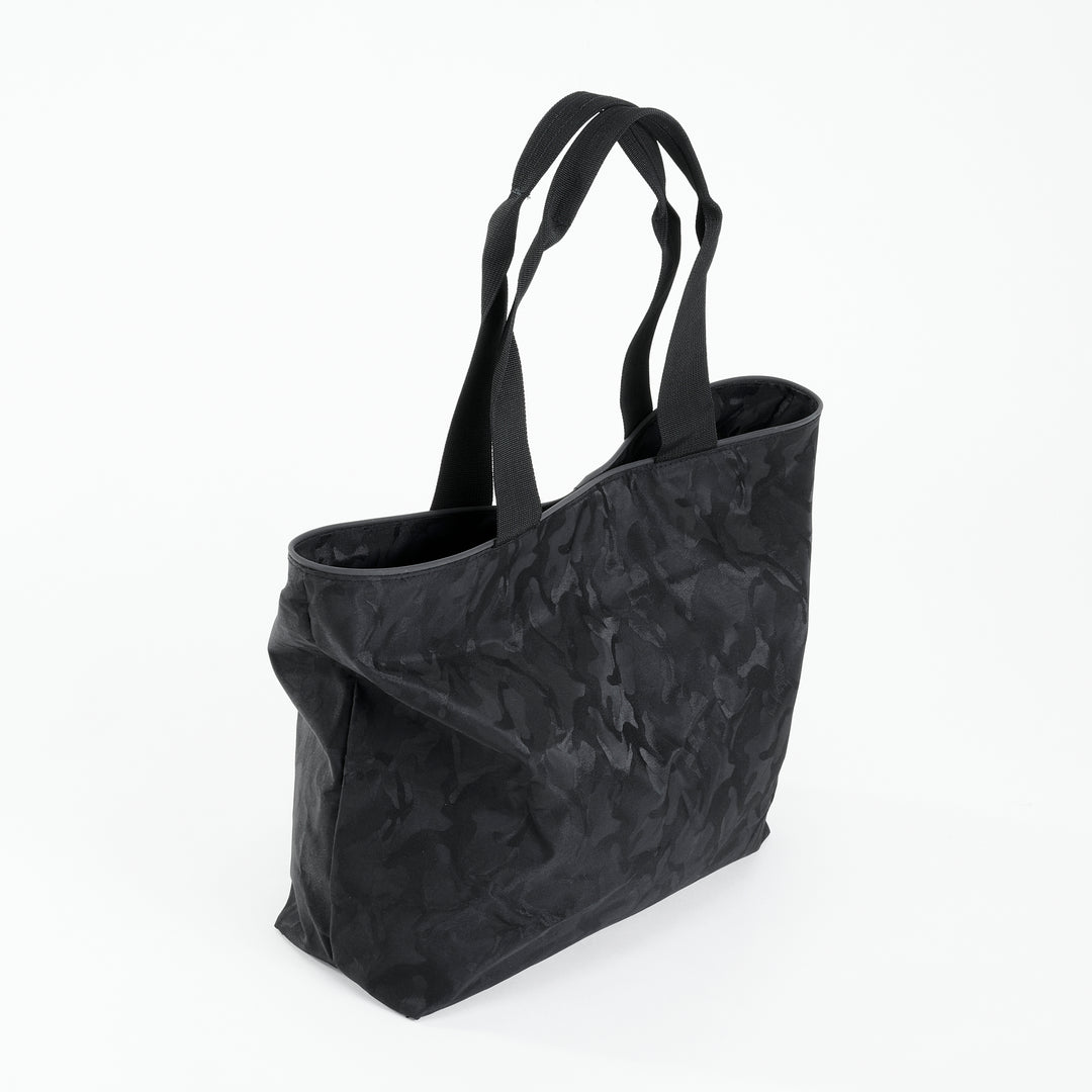 Side view of a black camo everyday tote bag