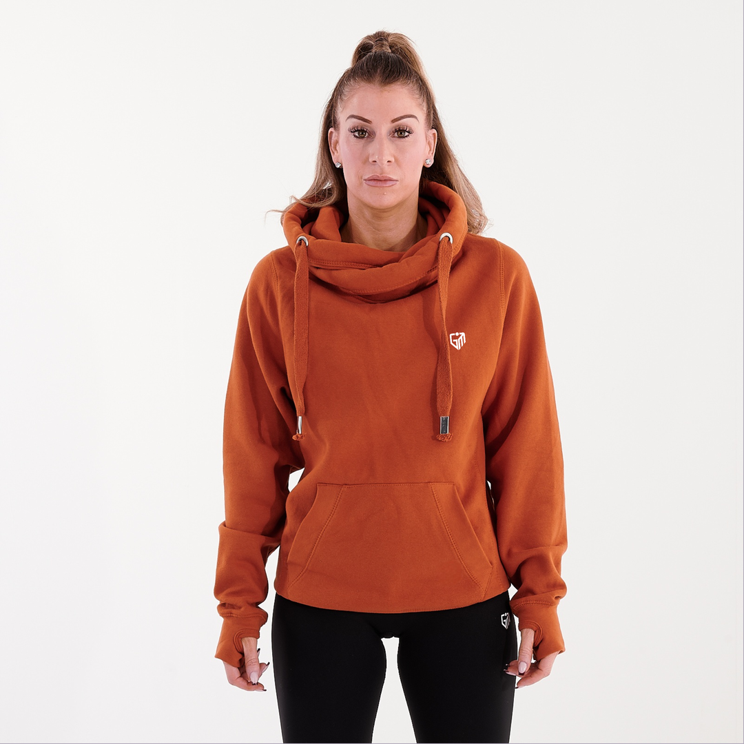 Front view of a woman wearing a orange heavyweight hoodie