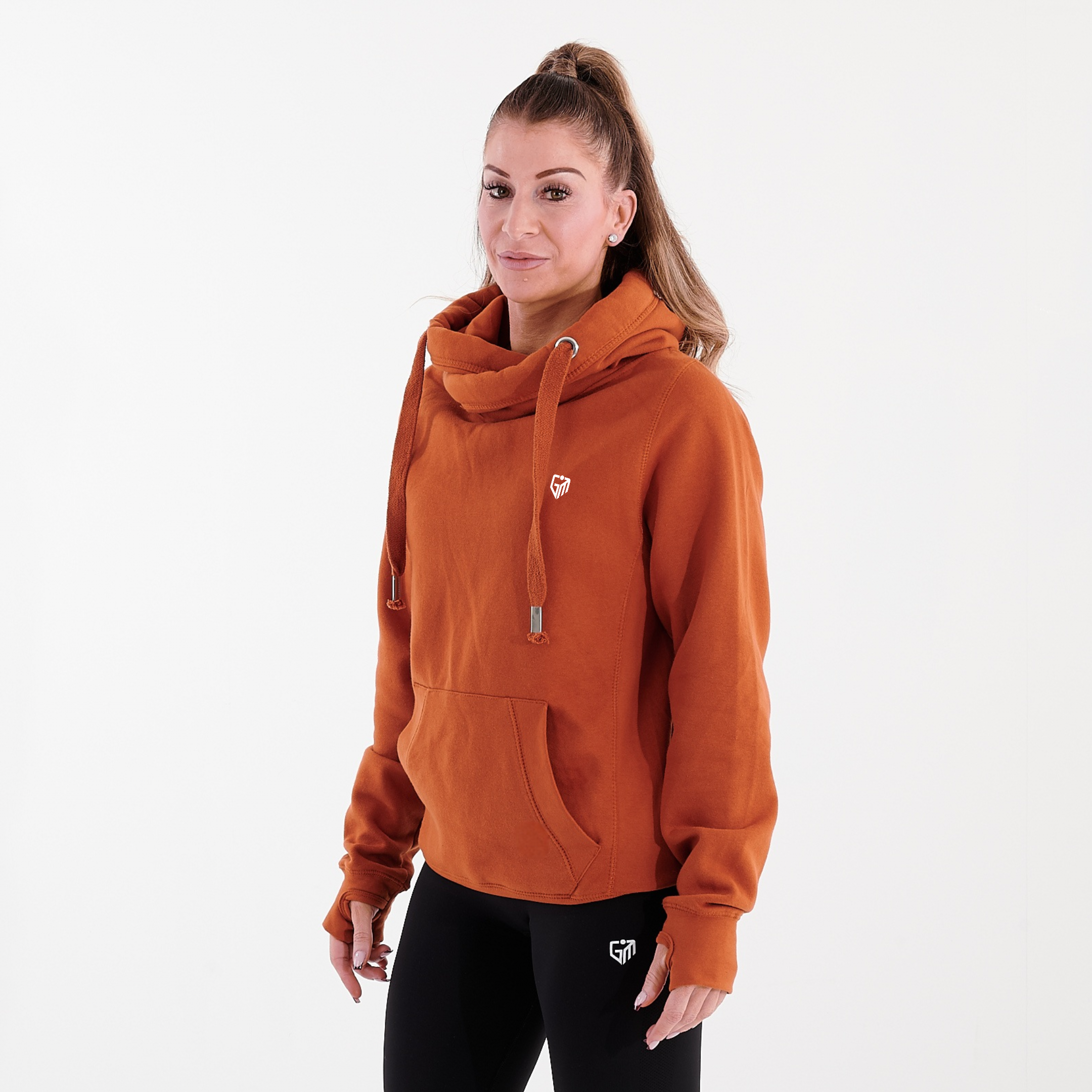 Side view of a woman wearing a orange heavyweight hoodie