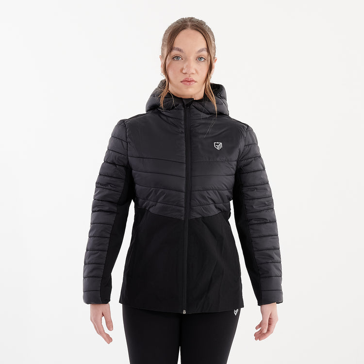 Front view of a woman wearing a black insulated hybrid jacket