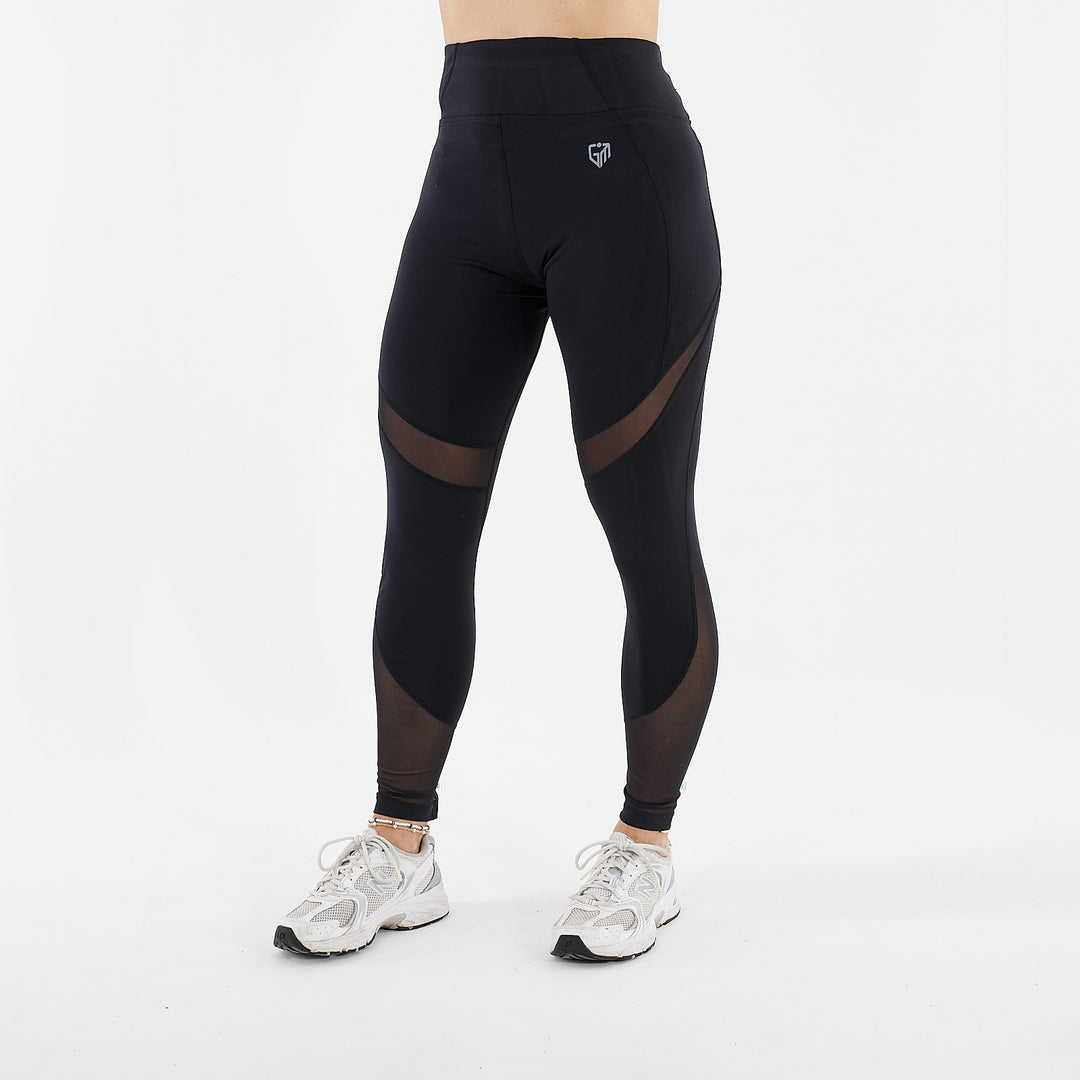 Side view of a woman wearing full length mesh panel leggings