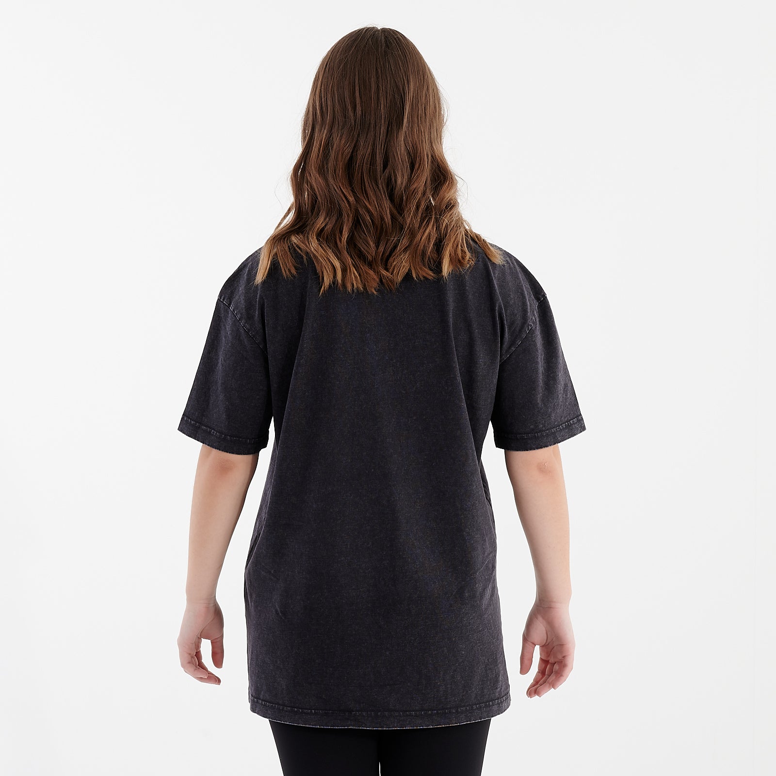 Back view of a woman wearing an oversized acid wash t-shirt black