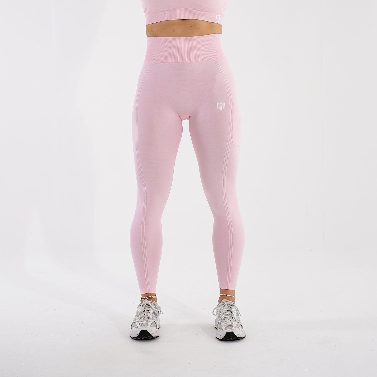 Front view of a woman wearing light pink recycled high waisted leggings