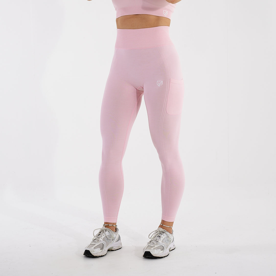 Side view of a woman wearing light pink recycled high waisted leggings