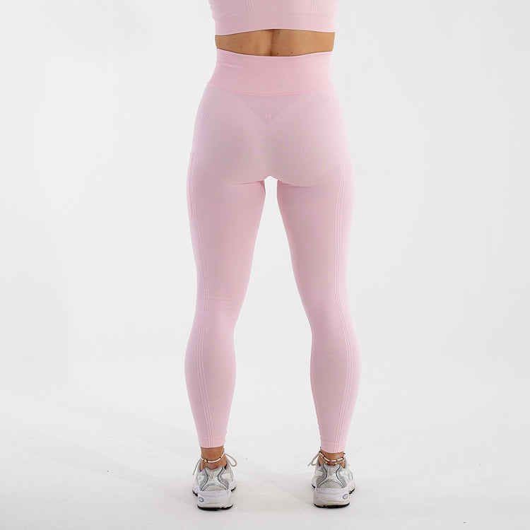 Back view of a woman wearing light pink recycled high waisted leggings