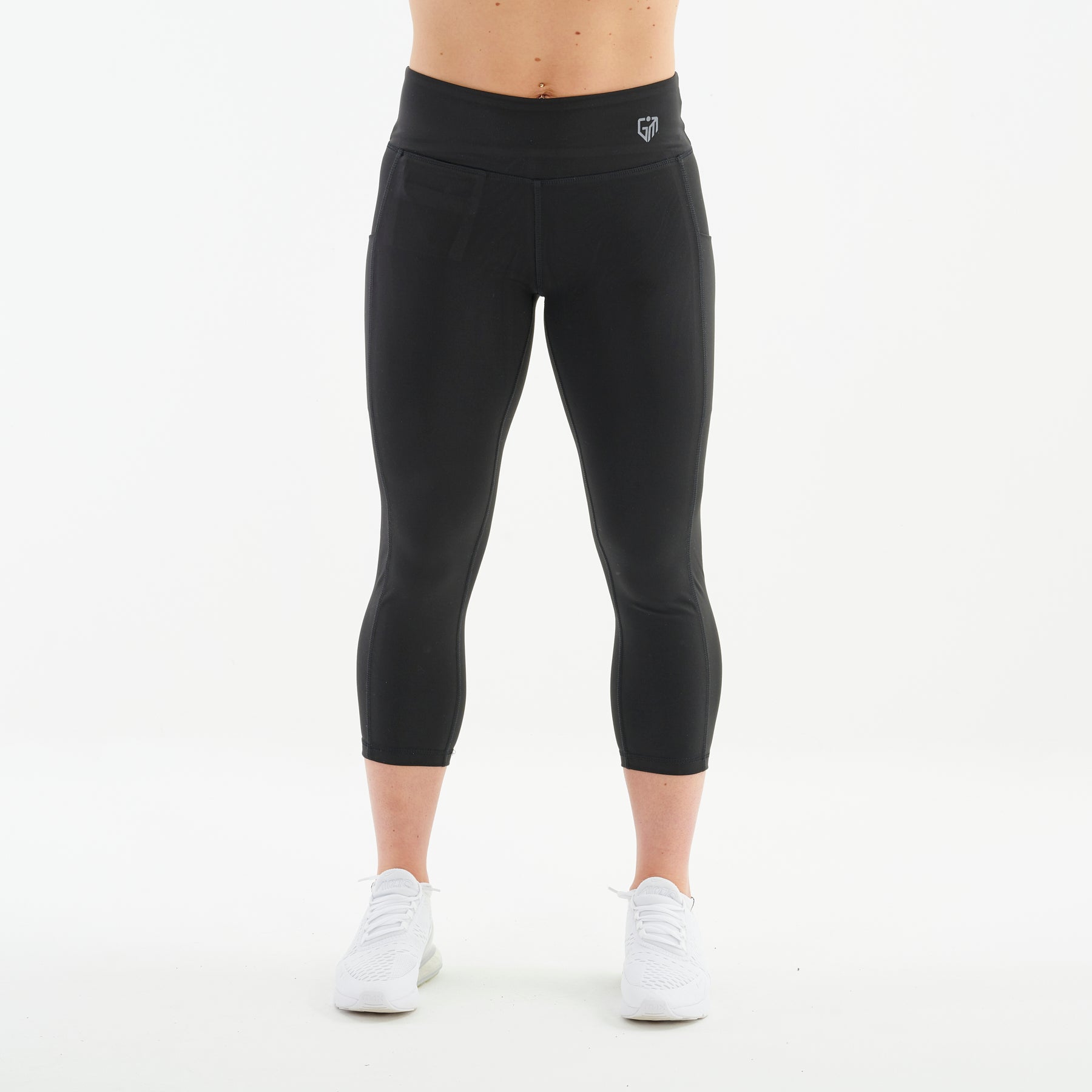 Front view of a woman wearing recycled 3/4 length performance leggings