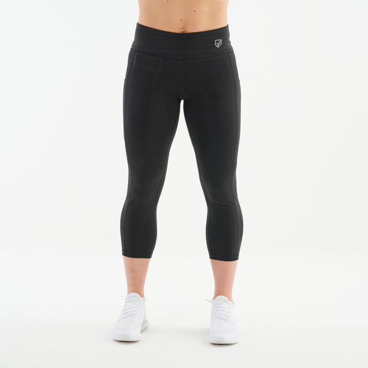 Front view of a woman wearing recycled 3/4 length performance leggings