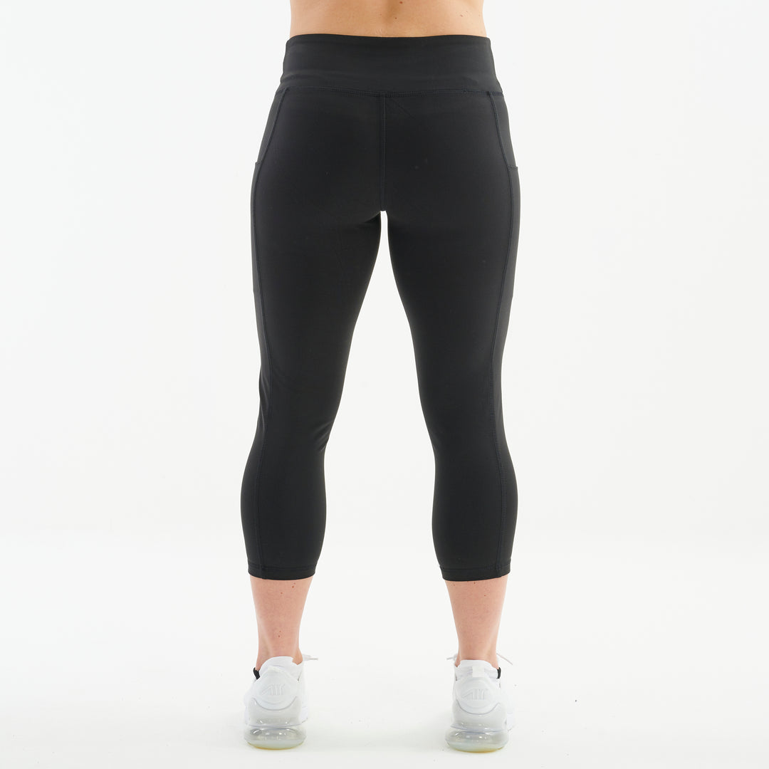 Back view of a woman wearing recycled 3/4 length performance leggings