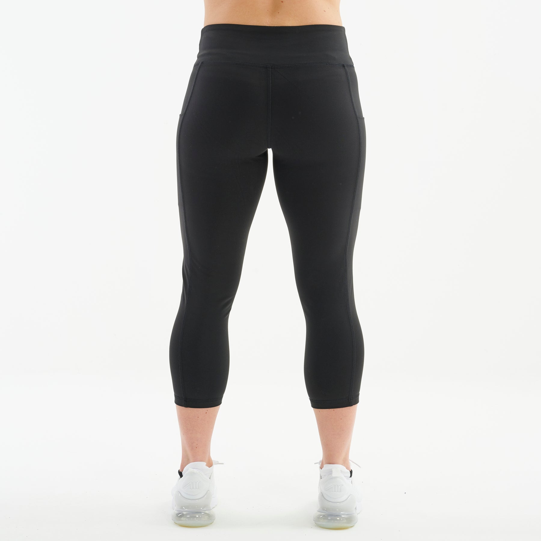 Back view of a woman wearing recycled 3/4 length performance leggings