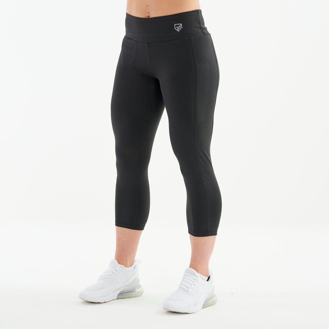 Side view of a woman wearing recycled 3/4 length performance leggings