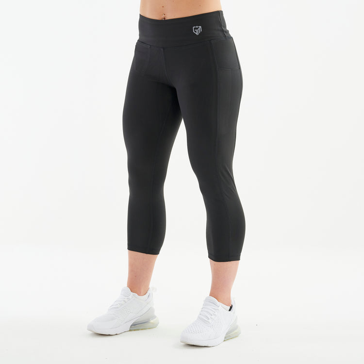 Side view of a woman wearing recycled 3/4 length performance leggings
