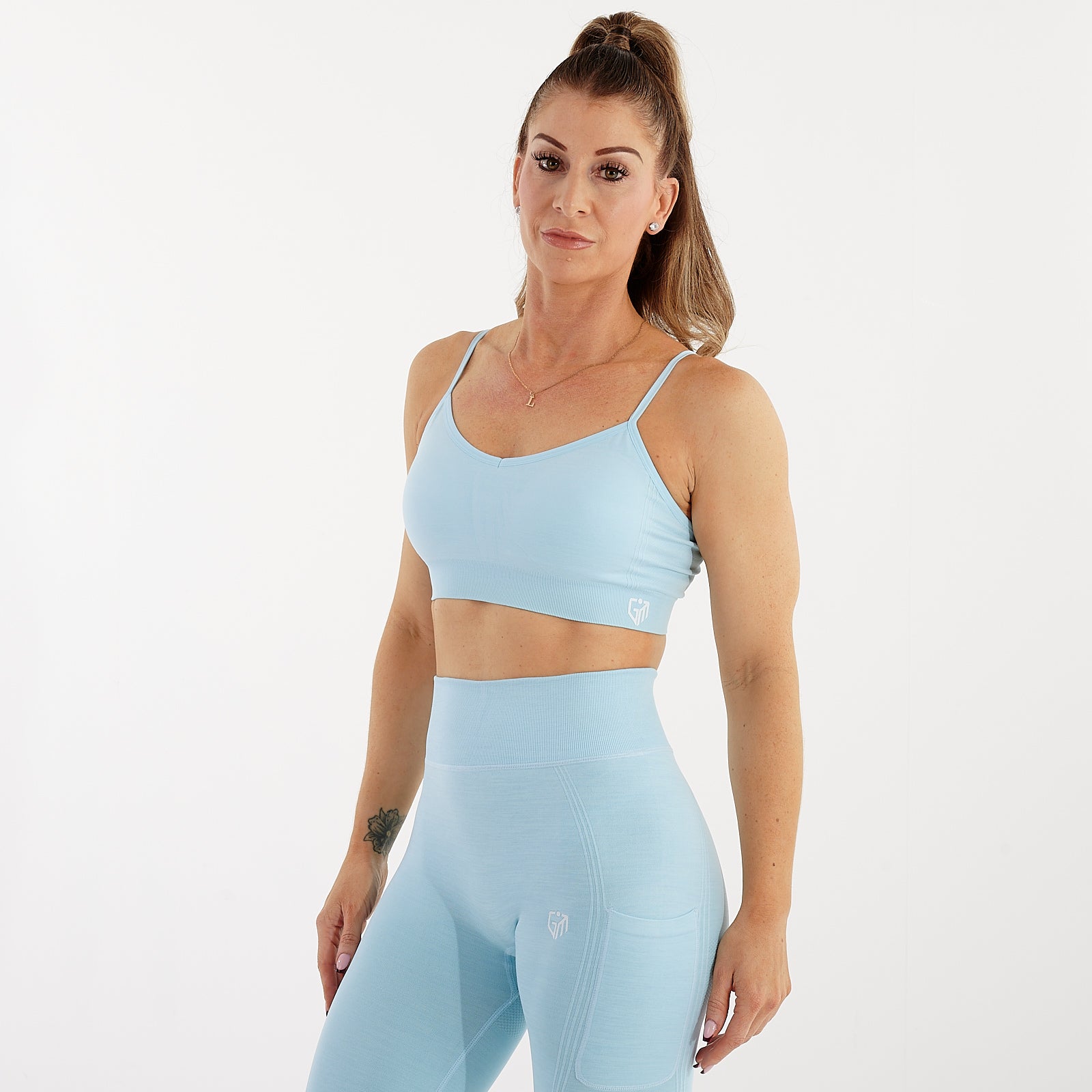 Side view of a woman wearing a sky blue seamless flex bra