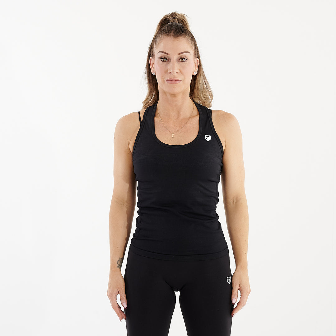 Front view of a woman wearing a black seamless racerback performance vest